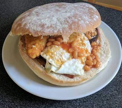 A bin lid bap with a whole Full English breakfast in it.