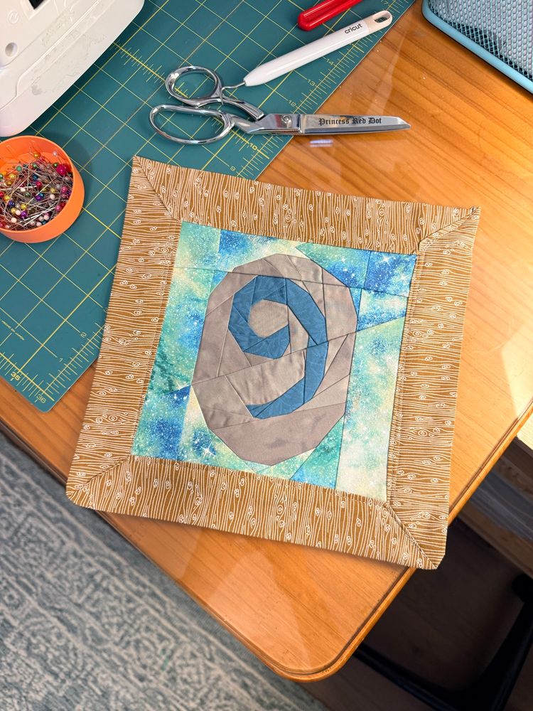 Blue, grey and brown quilt block featuring a hearthstone. 