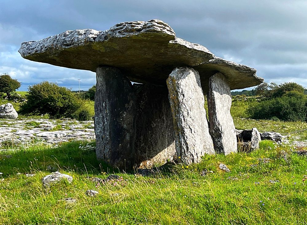 A photo of grey, limestone box-like monument made of flat slabs of stone.