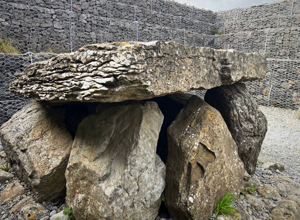 A photo of a chunky dolmen within a passage tomb.