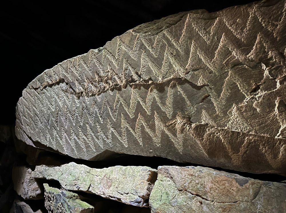A photo of another stone lintel decorated with zigzags.