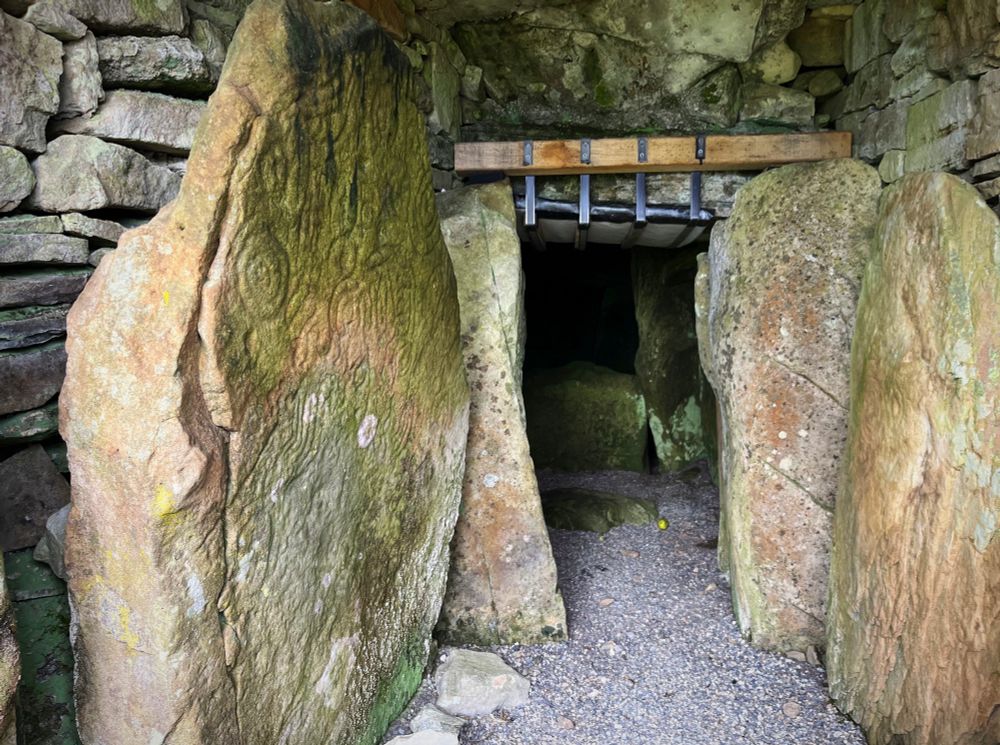 A photo of the view inside the passage tomb showing megaliths, some with pecked art on.