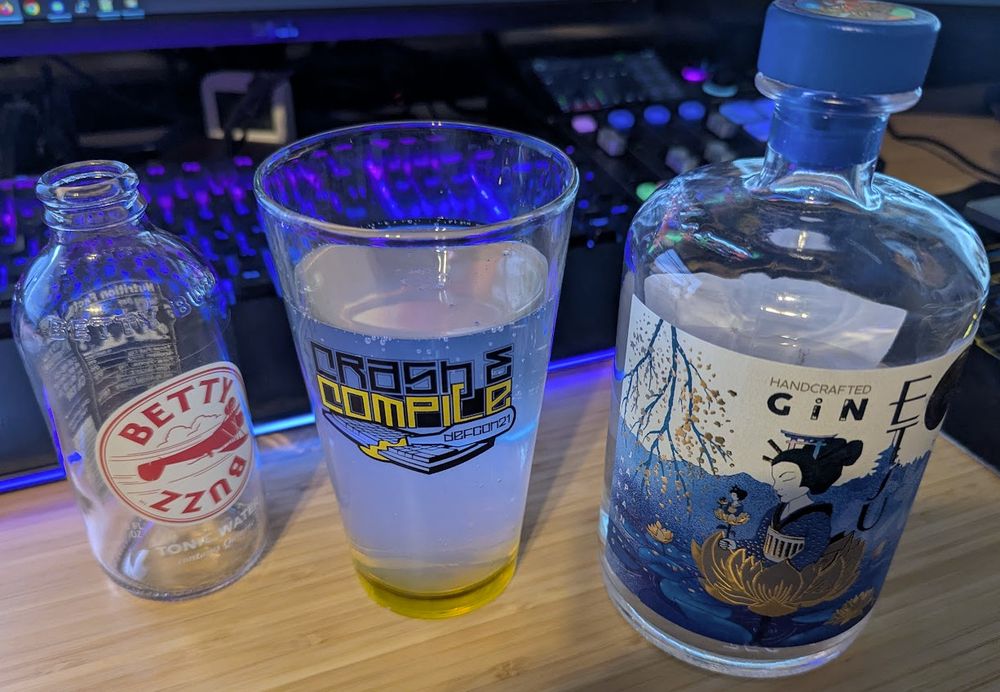 A Gin and Tonic made with Etsu Japanese Gin, and Betty Buzz tonic water, and a splash of lime, served in a DEF CON Crash and Compile pint glass.