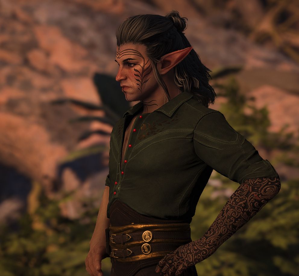 Mahanon Lavellan - a male elf rogue with long grey hair half-up in a rough bun, June's vallaslin on his face and throat, and a black and bronze prosthetic in place of his missing left arm. He's wearing a green and black version of the Crow casual outfit. 