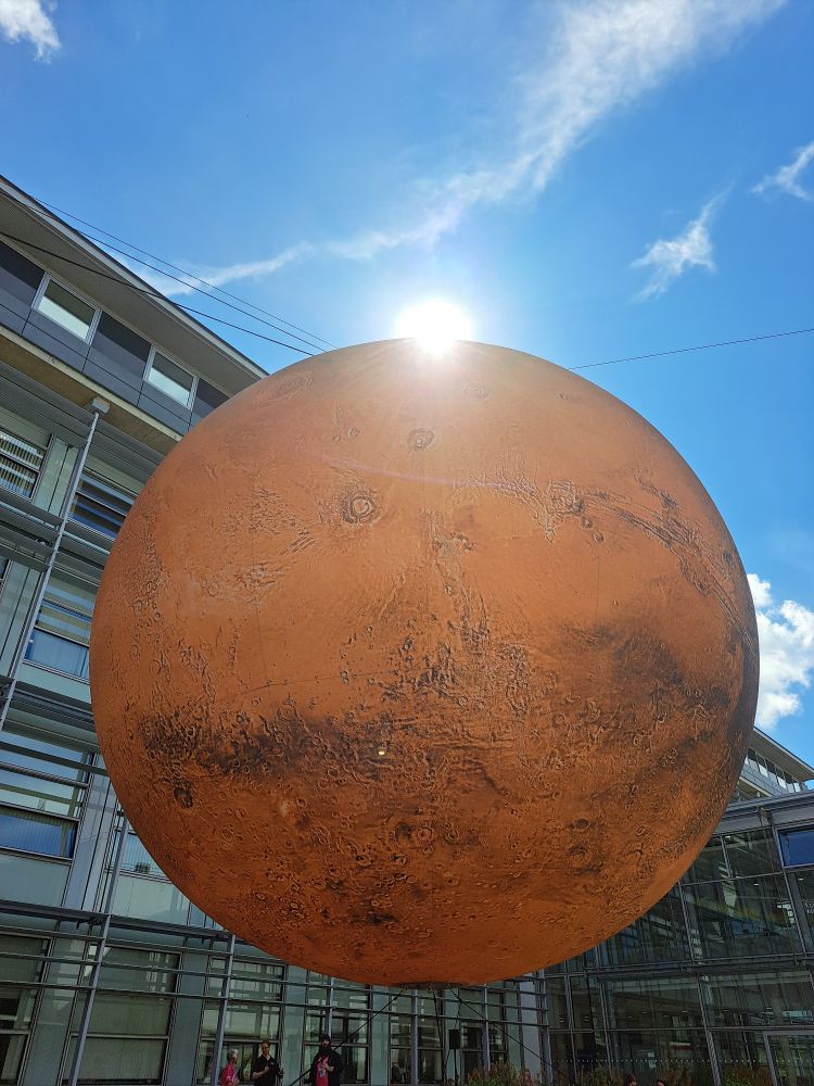 Sun peeps over Luke Jerram's Mars installation at The Open University in Milton Keynes