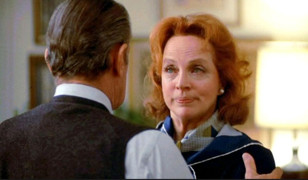 Oscar winning Best Supporting Actress Beatrice Straight crying, red hair, blue suit. Gripped by William Holden in vest, but we only see his back.