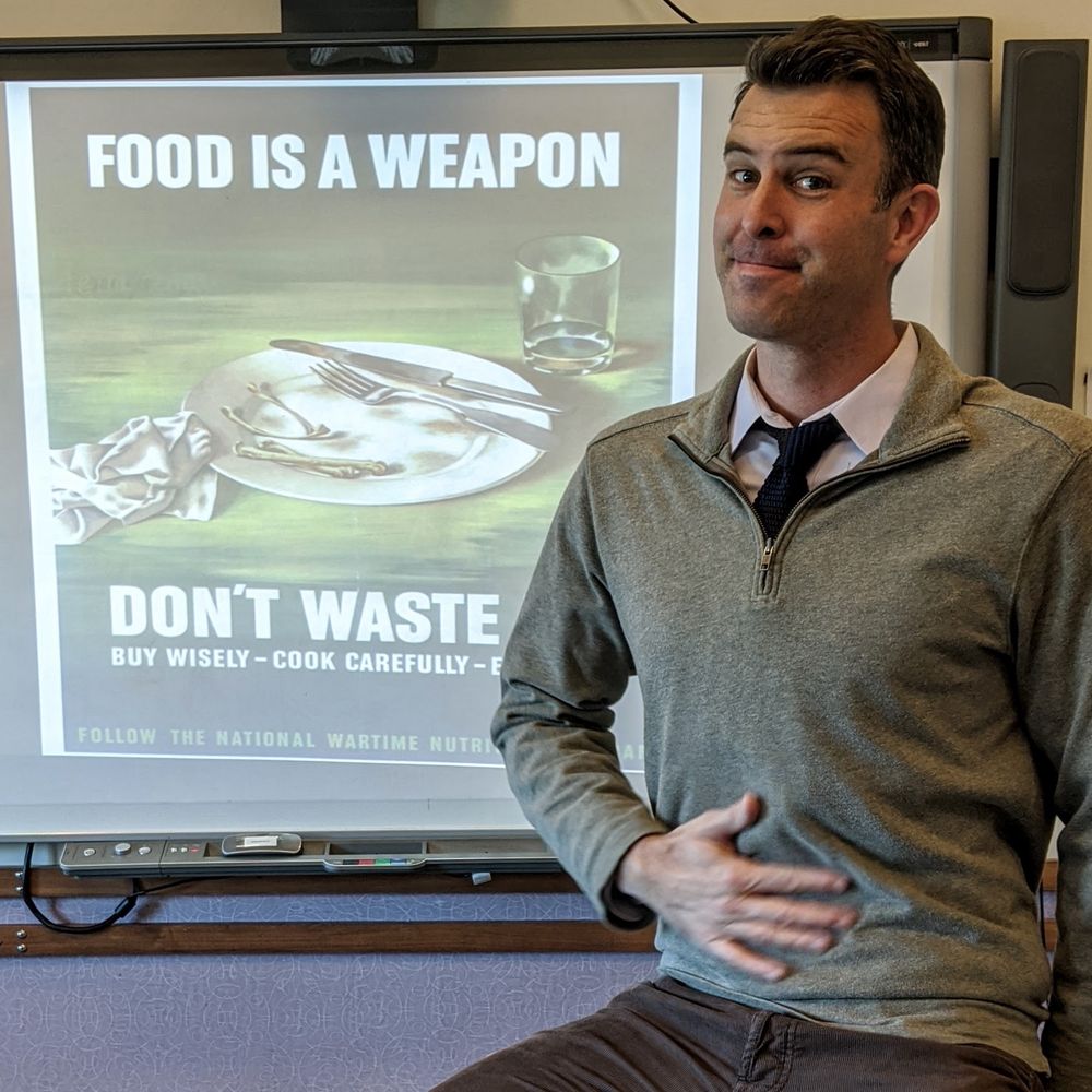 Myself (a teacher) in front of an old WW2 propaganda poster in a classroom. 