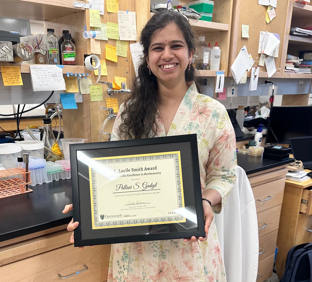 Pallavi holding an award certificate. 