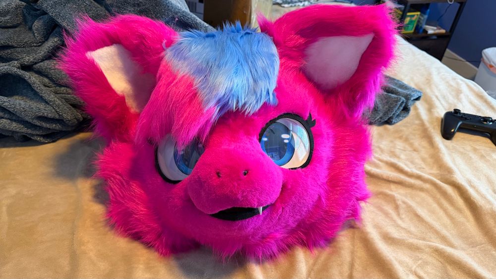 A Fursuit head of Magenta on my bed