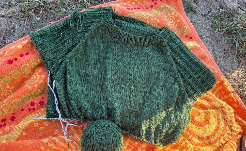 WIP of a green knit raglan tee on a beach towel 