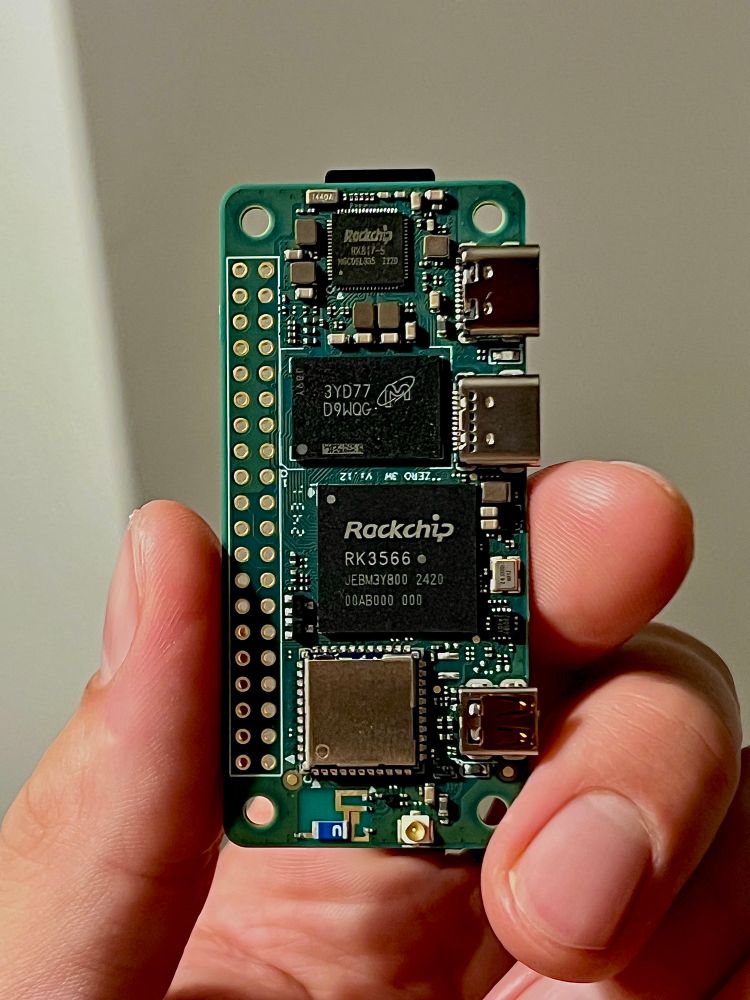 A hand, holding a credit-card sized Linux computer
