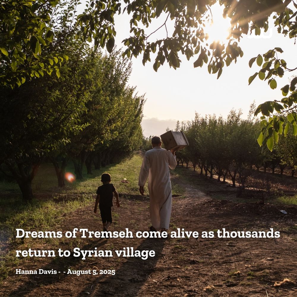 A recently returned Tremseh villager walks through an orchard with his young son, on his way to tend to his beehives, 19/7/2025
