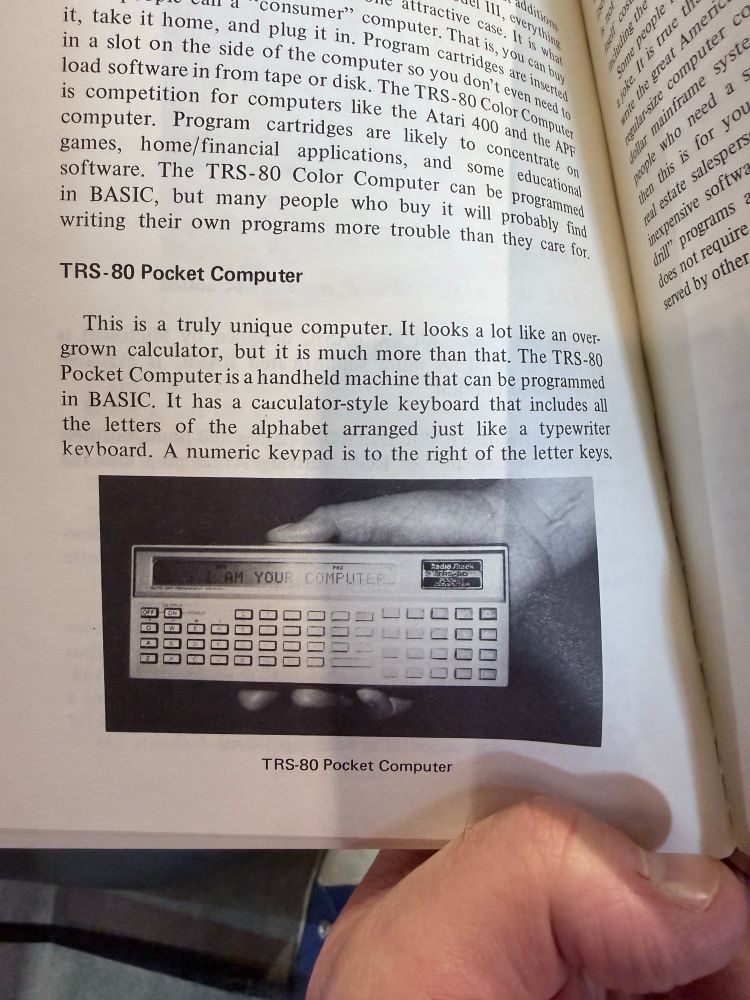 A picture of the TRS-80 personal computer, it’s a foot long rectangle with a small screen and multiple rows of keys underneath. Truly an early portable computer