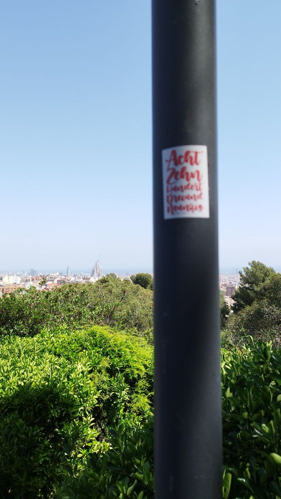 Ein 1893 Bäpper an einer Straßenlaterne, im Hintergrund die Sagrada Familia in Barcelona.