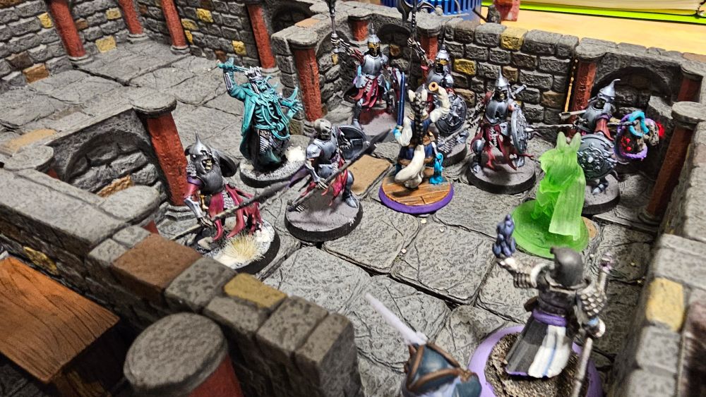 Picture of a stone cellar full of skeletons and some adventurers 