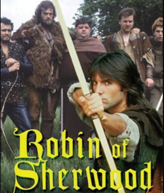 Michael Praed as Robin Hood points an arrow at the camera. The Merry Men stand behind him. Yellow text read "Robin of Sherwood".