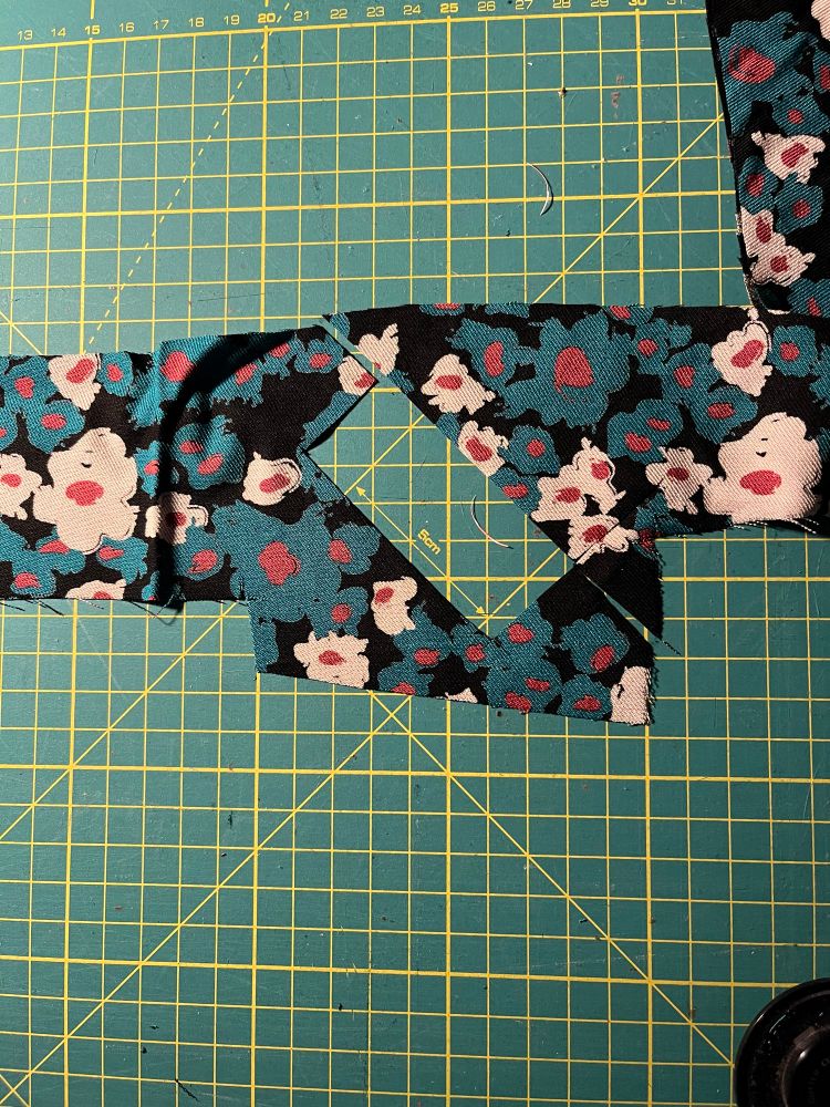 A diagonally cut rectangle shape silhouette. Cut out of fabric with flowers
