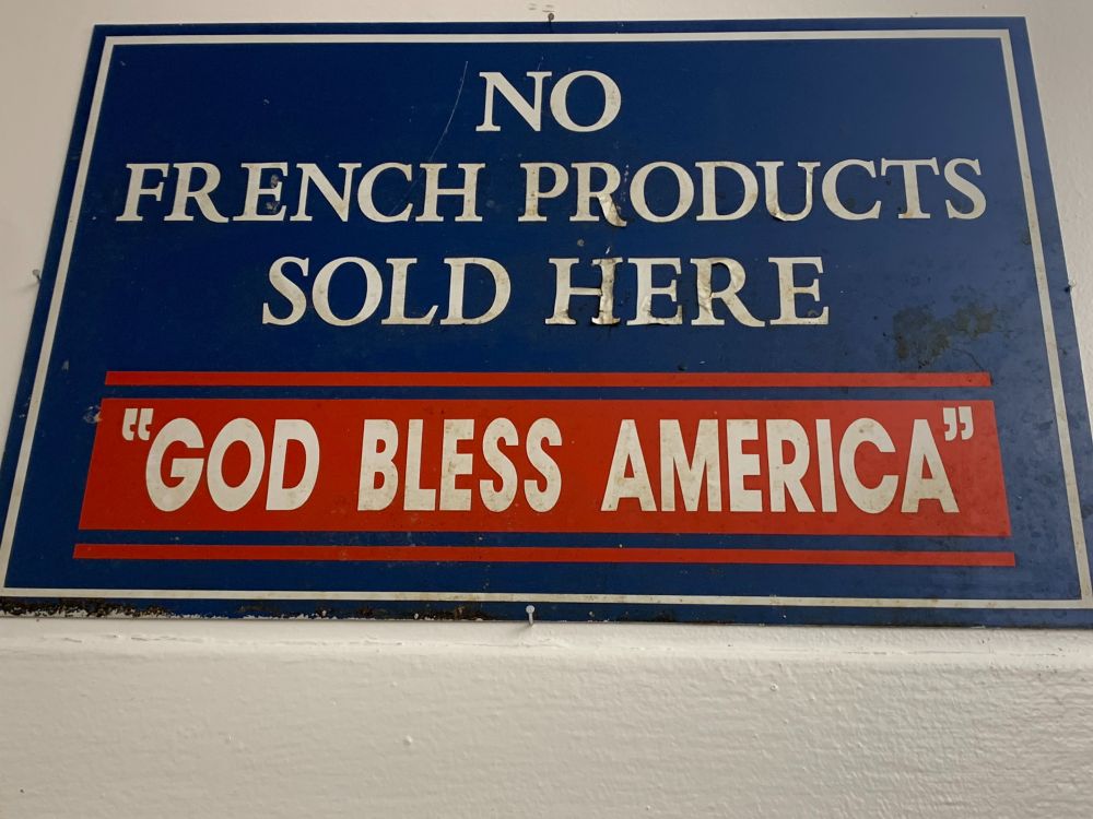 sign reading NO FRENCH PRODUCTS SOLD HERE, "GOD BLESS AMERICA"