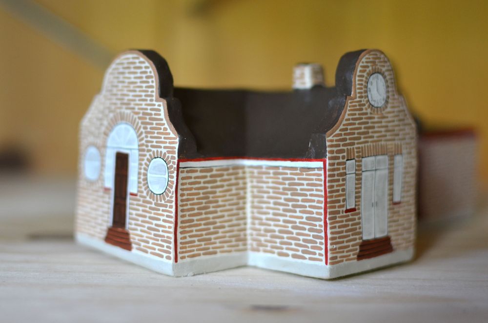 Little painted clay model of the Taskmaster House (front and patio door).