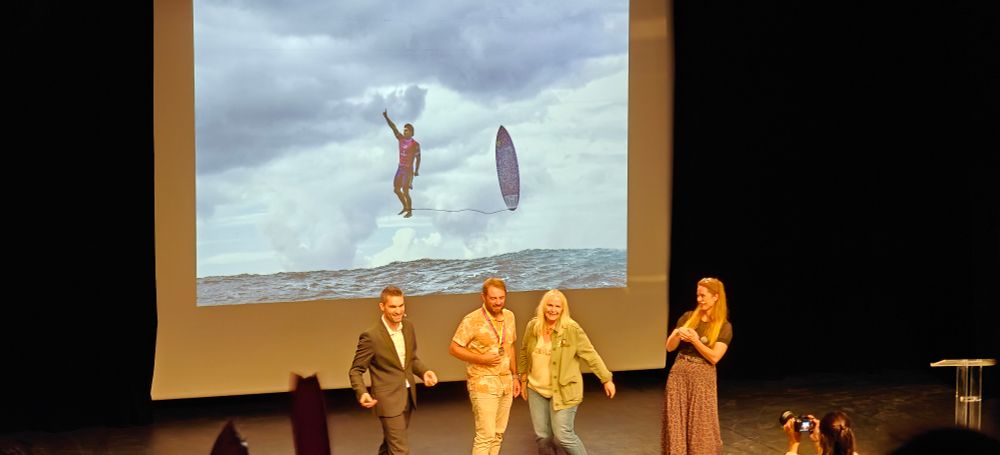 Le photographe Jérôme Brouiller sur scène, devant sa photo du Brésilien Gabriel Medina 