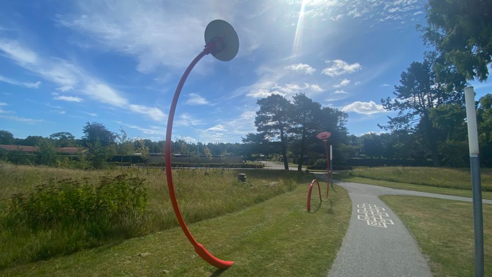 A picture of two lamp posts. They are both unusually bent in a way that could be interpreted as a dramatic scene