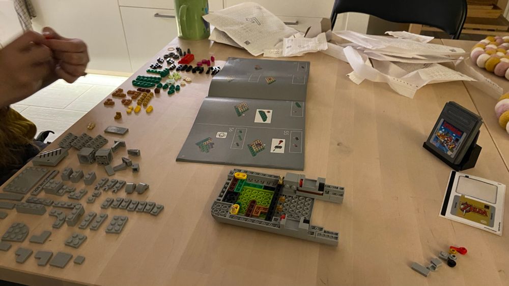 A dining table covered in Lego and building instructions