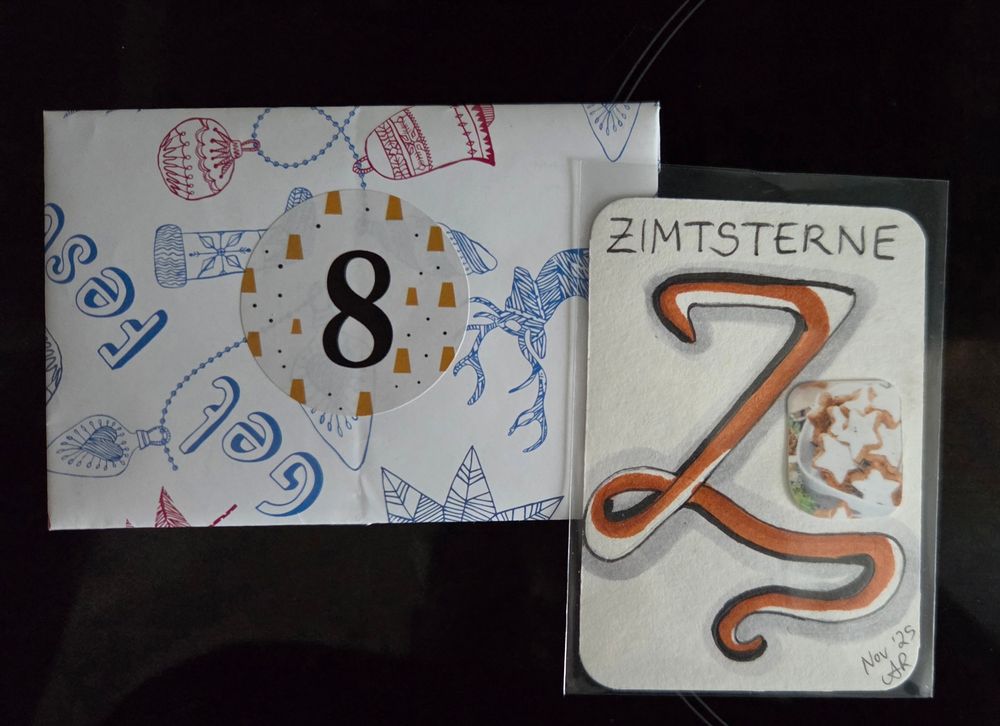 Oben links: Geschenkpapierumschlag in weiss mit blauen und roten Weihnachtsmustern. In der Mitte eine schwarze 8. Unten rechts: ATC Karte. Braunes Z über die gesamte Karte. Oben "Zimtsterne" in Grossbuchstaben geschrieben. In der Mitte rechts ein Foto von Zimtsternen.