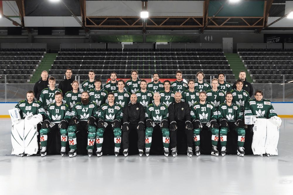 Photography of first team of mens EHC Olten. Shows all players in 3 rows sitting and standing in the ice rink