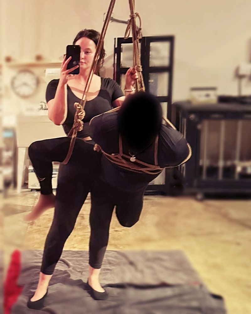 Rahul suspended in the dungeon with rope in the classic running man using Kinoko’s 3rd rope TK. Front View with Mistress Akira