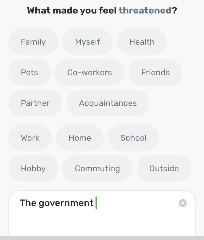 Screenshot of an app with a prompt question “what made you feel threatened?” With a list of terms to select including family, myself, health, pets, co-workers, friends, partner, acquaintances, work, home, school, hobby, commuting, & outside, as well as a box to type your own text where I have written “the government.”