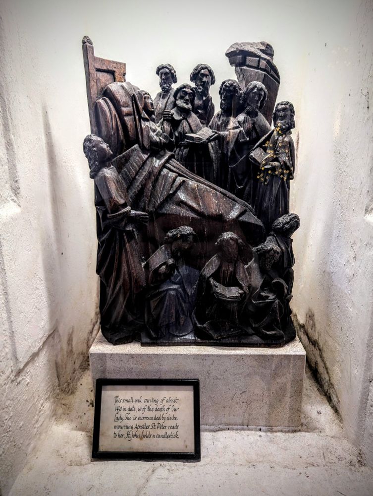 A wooden carving of Mary (mother of Jesus) surrounded by the disciples who are consoling her after Jesus' death