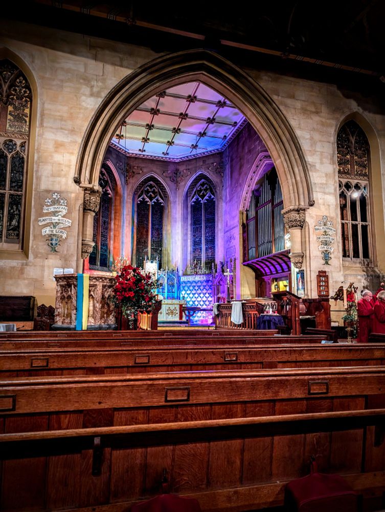 St Stephen's Church Bath set up for Midnight Mass with rainbow lights around the altar. 
