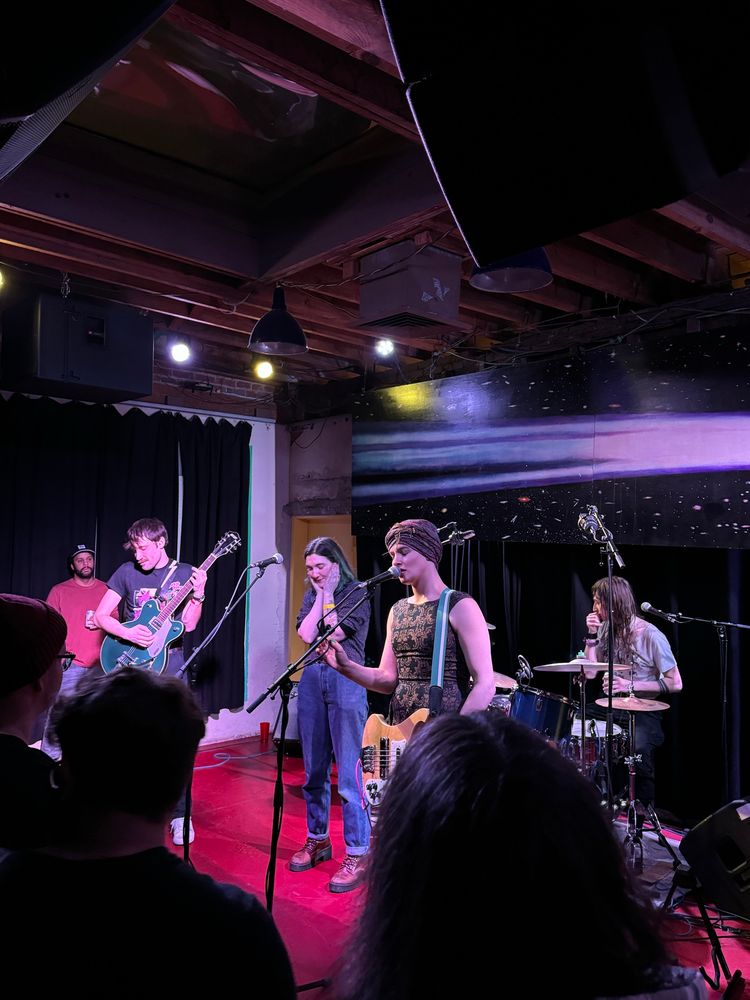 Ekko Astral with Pretty Bitter’s Emelia Bleker on a red stage performing at Comet Ping Pong