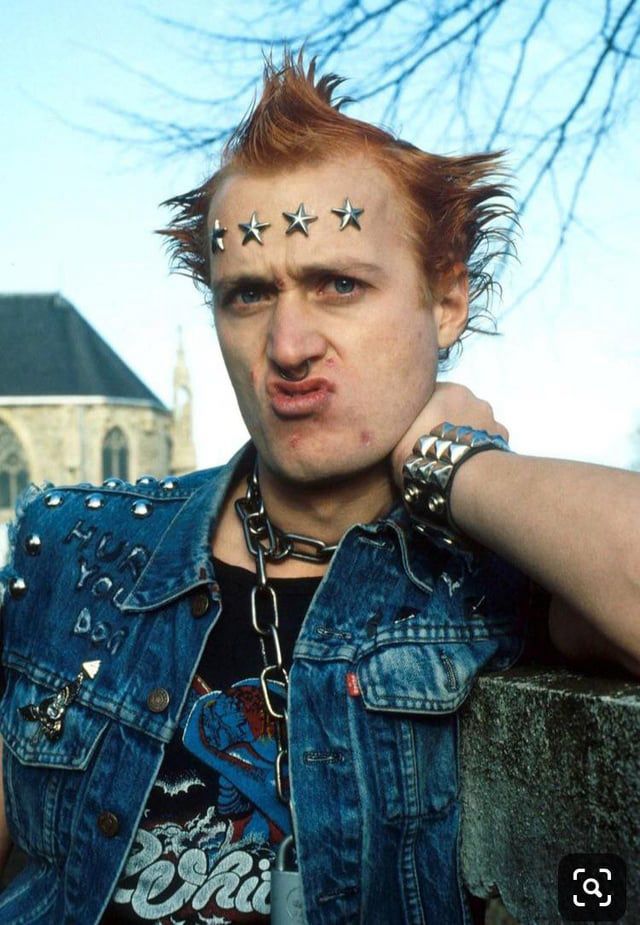 Vivían, a punk rocker with a battle vest, star stuffed forehead decorations, and spiky orange hair from the young ones tv show 