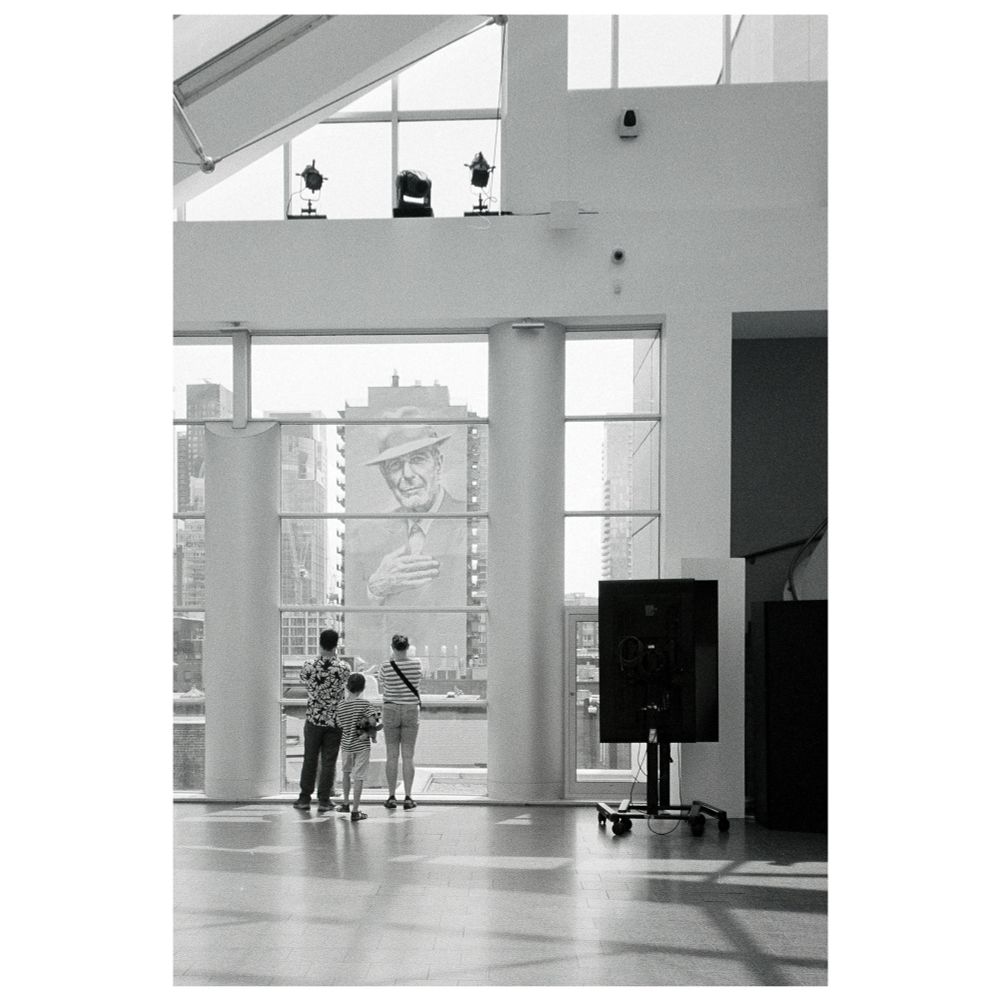 Photo of three tourist gazing on a Leonard Cohen mural from Montreal’s Art Museum