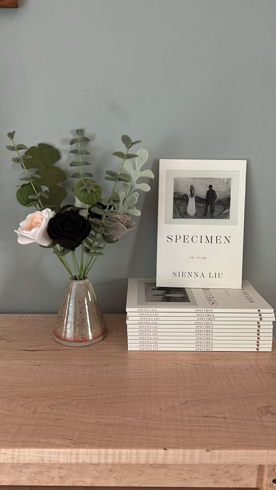 felt flowers and copies of Sienna Liu's SPECIMEN on a table