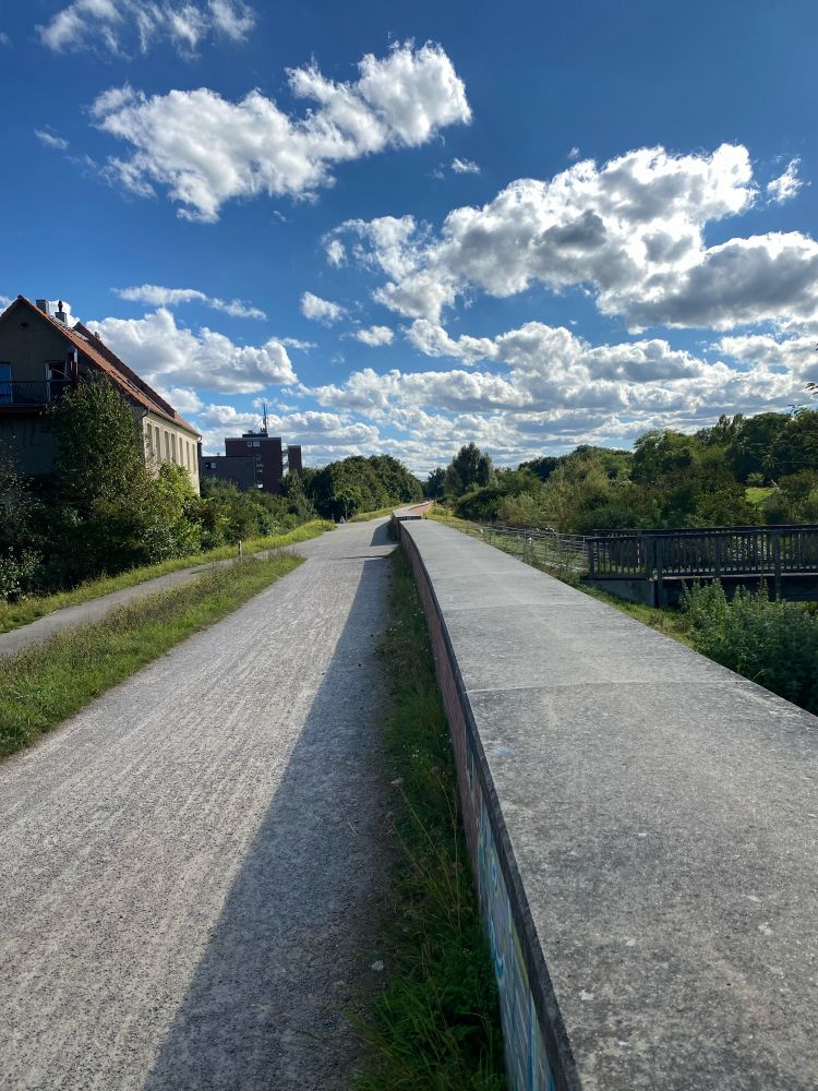Foto zeigt Teil der Laufstrecke am Brückerbach mit schönem blauen Himmel voller weißer Wolken.