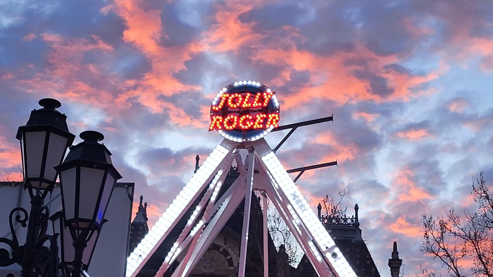 Ciel de soirée nuages rose rouges avec un néon de manege au premier plan 