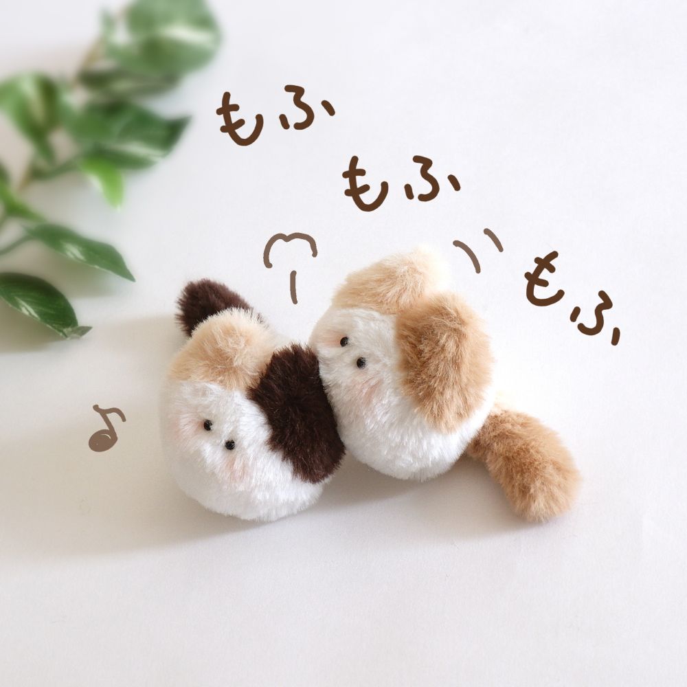 毛づくろいする猫のぬいぐるみ