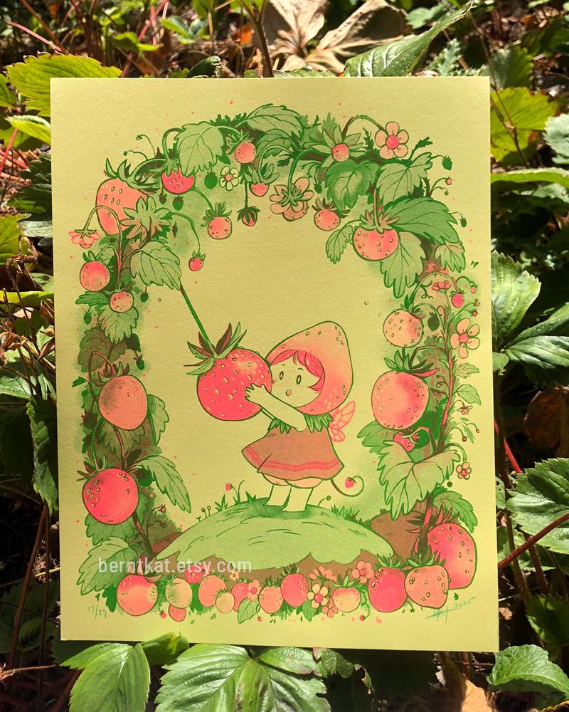 The same print, but a photo of it. The pink is a lot more saturated and highlighted. The print sits among a patch of strawberries. 