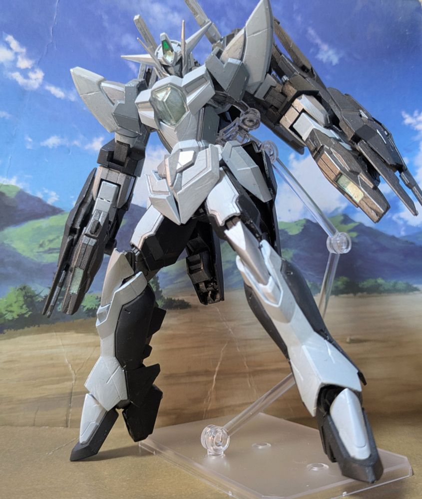 ガンダムビルドファイターズ バトローグに登場した改造ガンプラ。
リボーンズガンダム オリジンをヒントに元PPSEエンジニアのアラン・アダムスが製作。短所を出来るだけ改善したオリジナルの変形ギミックを詰め込んでいる。
劇中ではアニメキャラを再現した疑似人格AIを搭載し、再現されたシャア・アズナブルのバリスティックザクと対戦した。