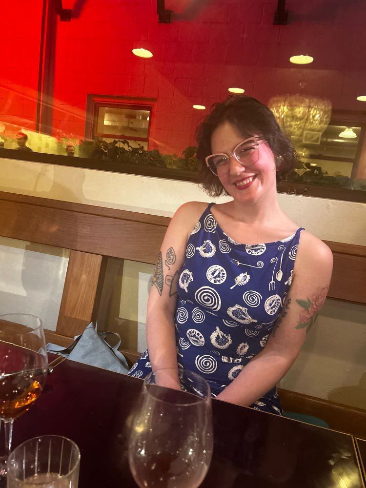 a picture of me smiling, i’m wearing a blue dress and i have v cute tattoos