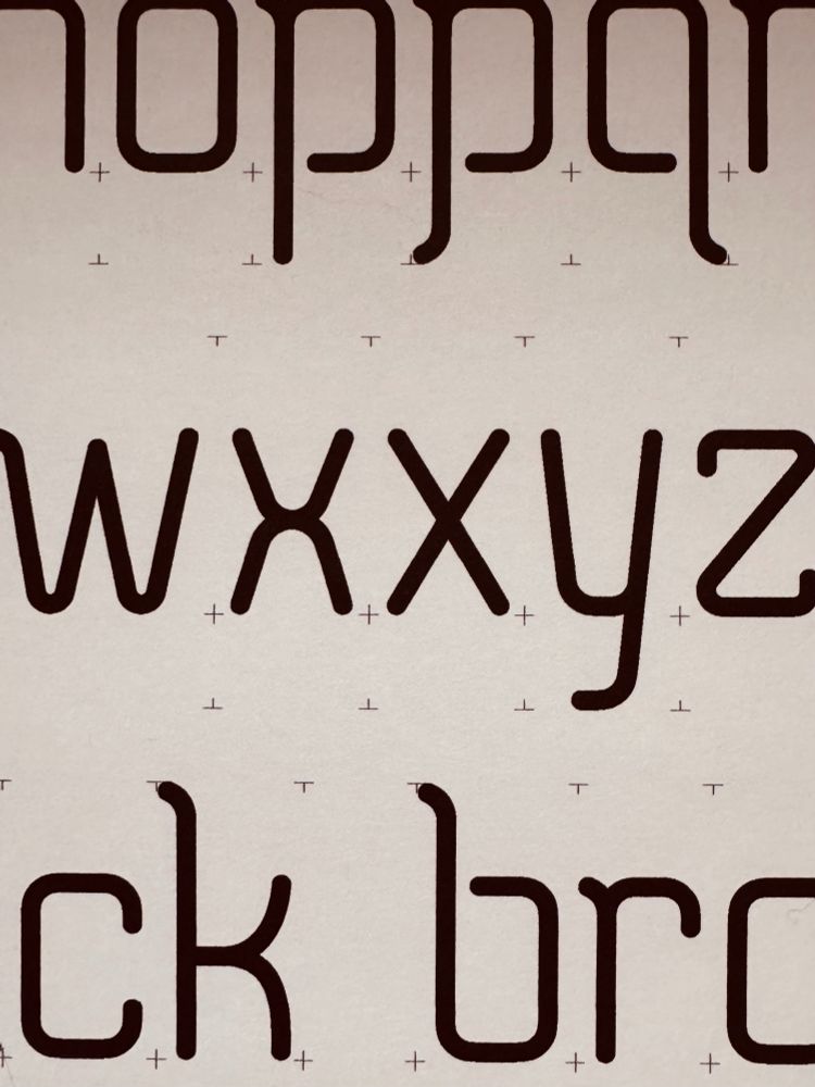 Image displaying a series of letters in a modern, stylized font, arranged in a random order over a pale background. The letters have small plus signs and t marks strategically placed around them.