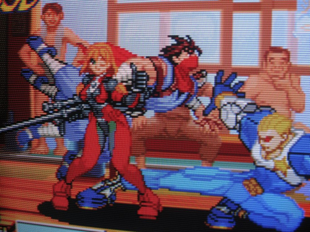 Capcom's forgotten hot guys Strider Hiryu and Captain Commando kung-fu battle in a steamy bathhouse. A middle-aged patron watches the melee from behind, getting a real good look at their backsides, and strokes his chin with great interest. Capcom's Saki is also present, giving a thumbs up after having just whiffed on her sniper shot. Her job here is done!