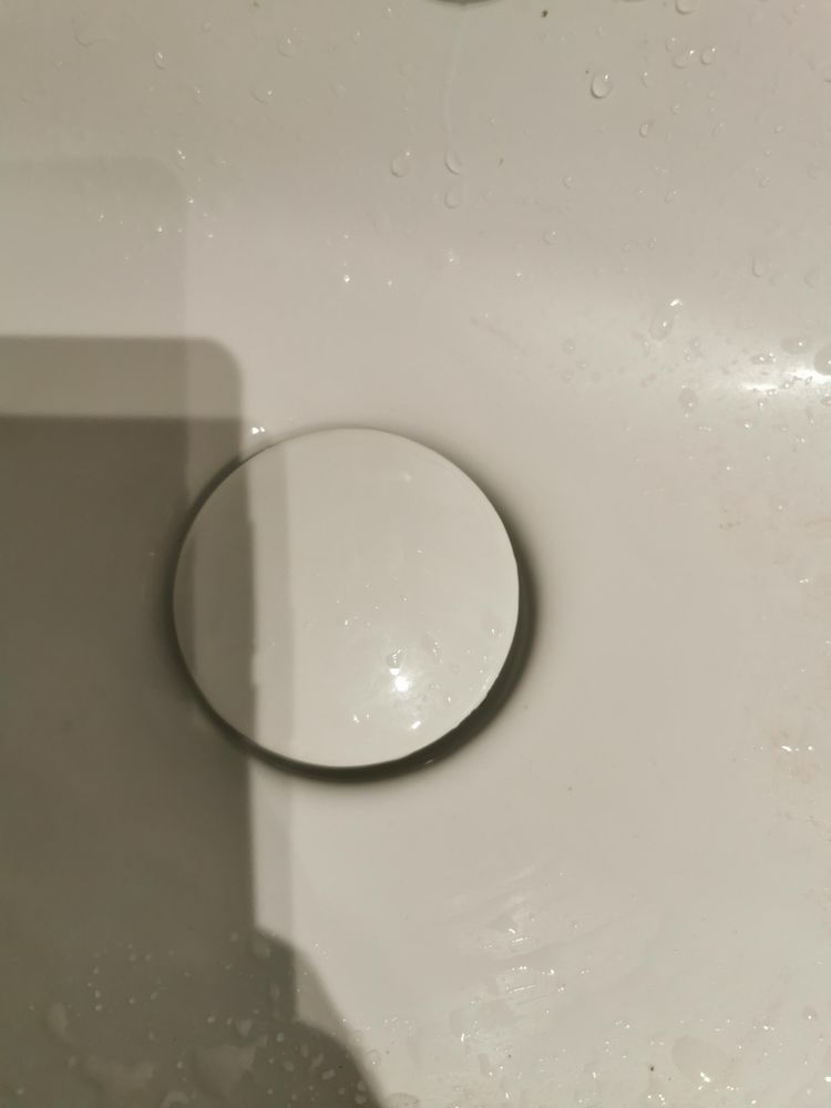 Weißes Waschbecken mit weißen Pushup Stöpsel.