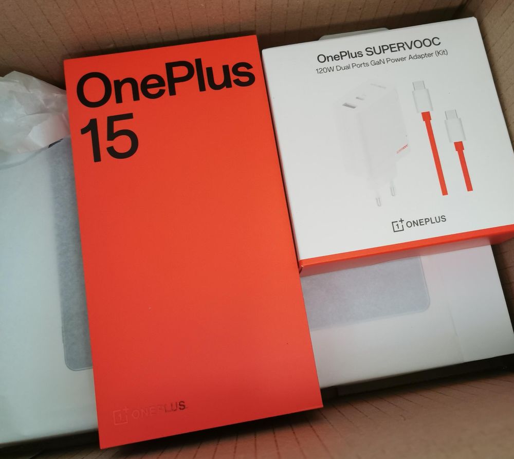 Oneplus 15 in einem roten Karton, daneben ein Schnellladegerät. Darunter ein tablet. Aber man sieht es nicht.

Alles liegt in einen Versendekarton
