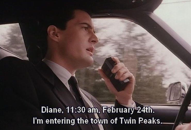Agent Dale Cooper speaks into his audio recorder while driving. Subtitle says, "Diane, 11:30 am, February 24th. I'm entering the town of Twin Peaks."