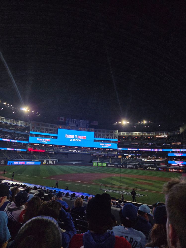Empty skydome field with screens in the back that say "bring it home"