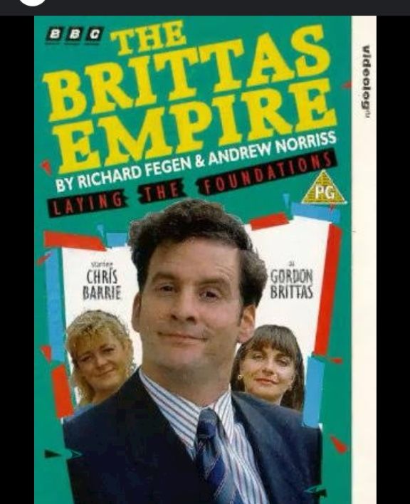 A promotional poster for the British TV show, The Brittas Empire which shows the actor Chris Barrie in w suit and tie below the name of the show 