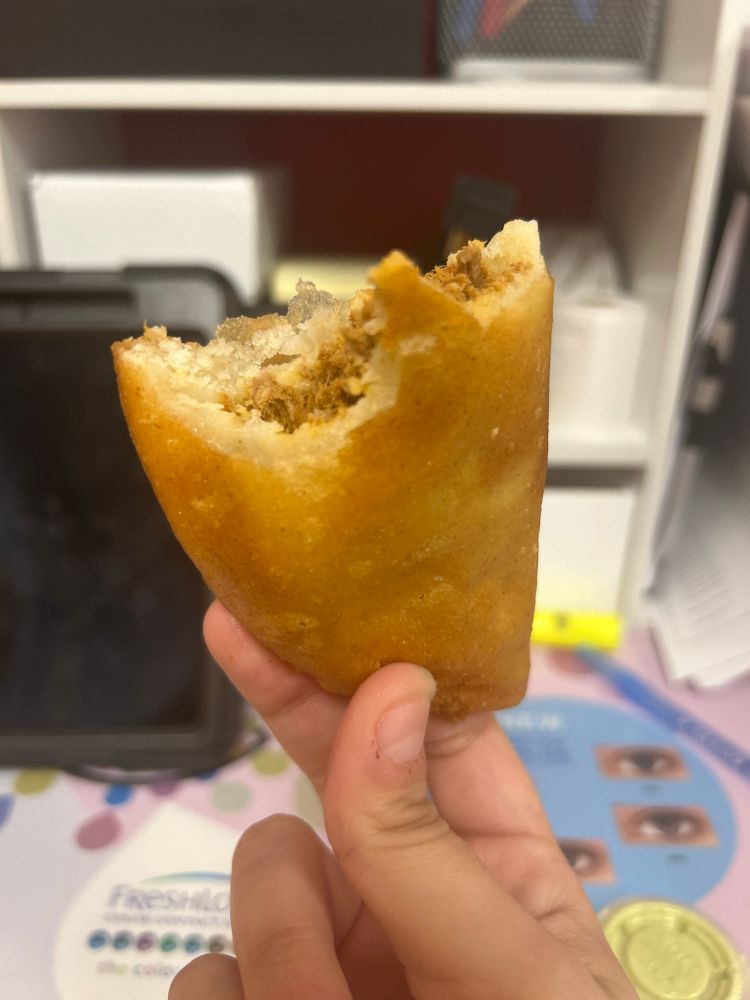 A half-eaten empanada featuring my man hands 